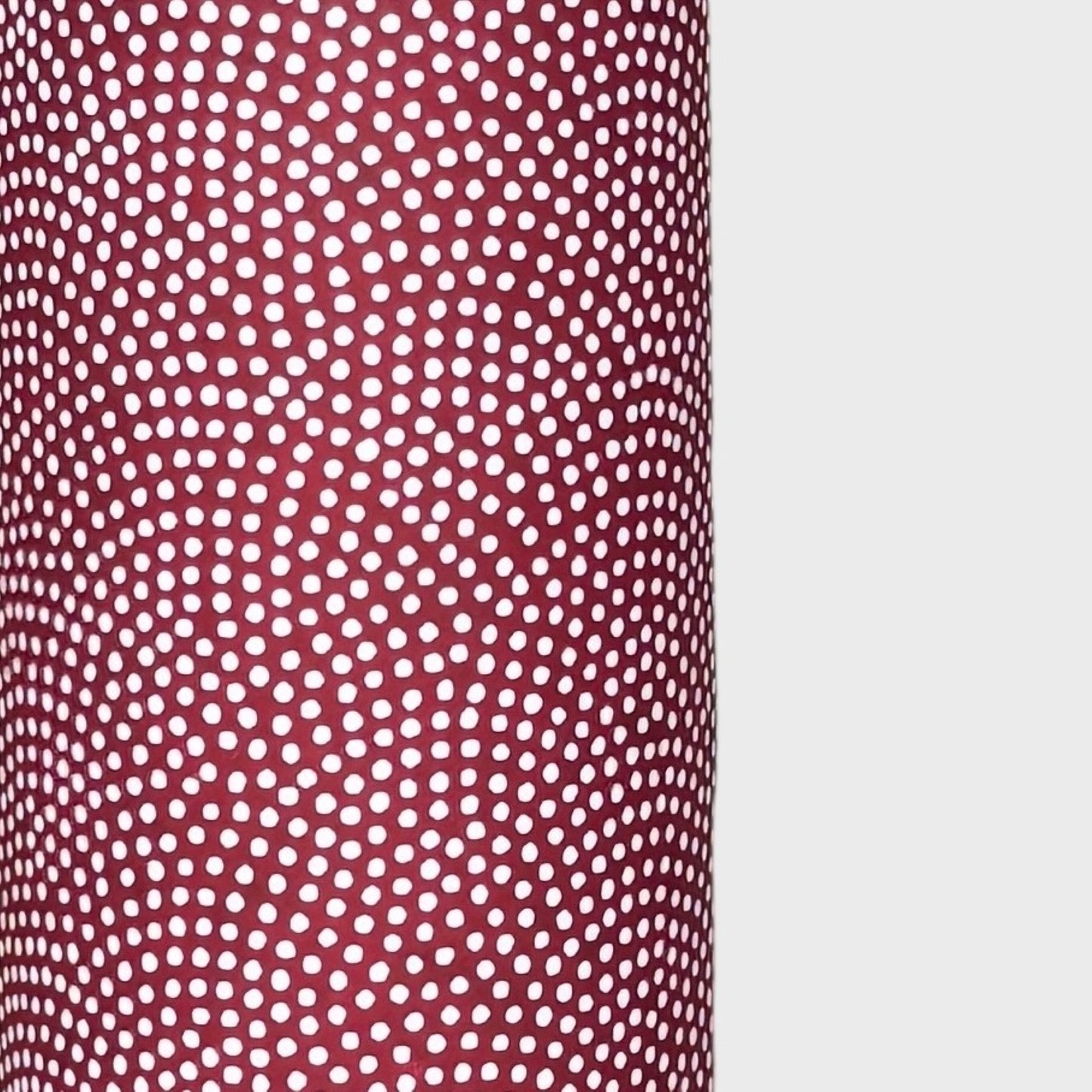 a sheet of Japanese chiyogami paper with an aubergine background and a small repeat pattern of tiny white dots in an arch shape