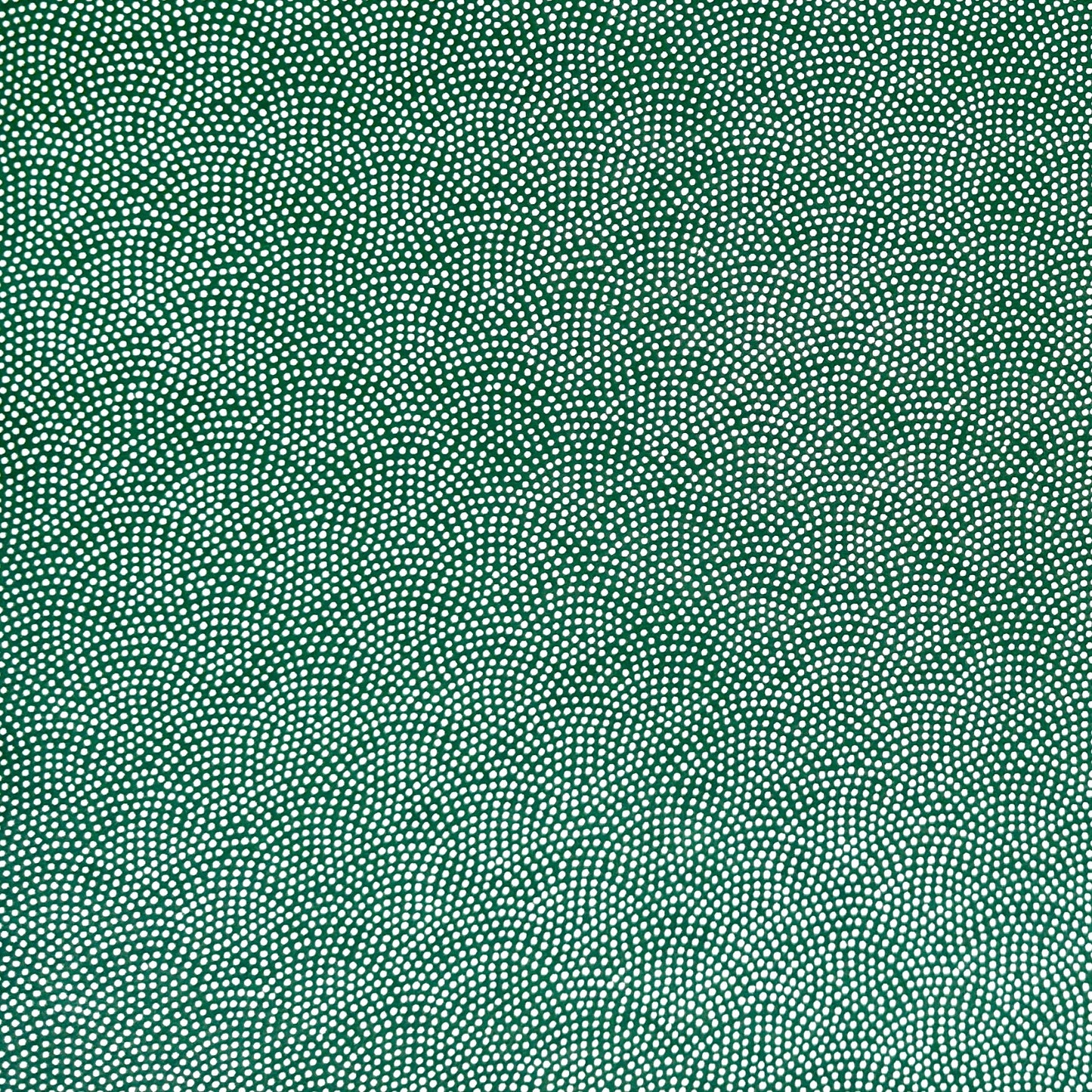 a sheet of Japanese chiyogami paper with a forest green background and a small repeat pattern of tiny white dots in an arch shape