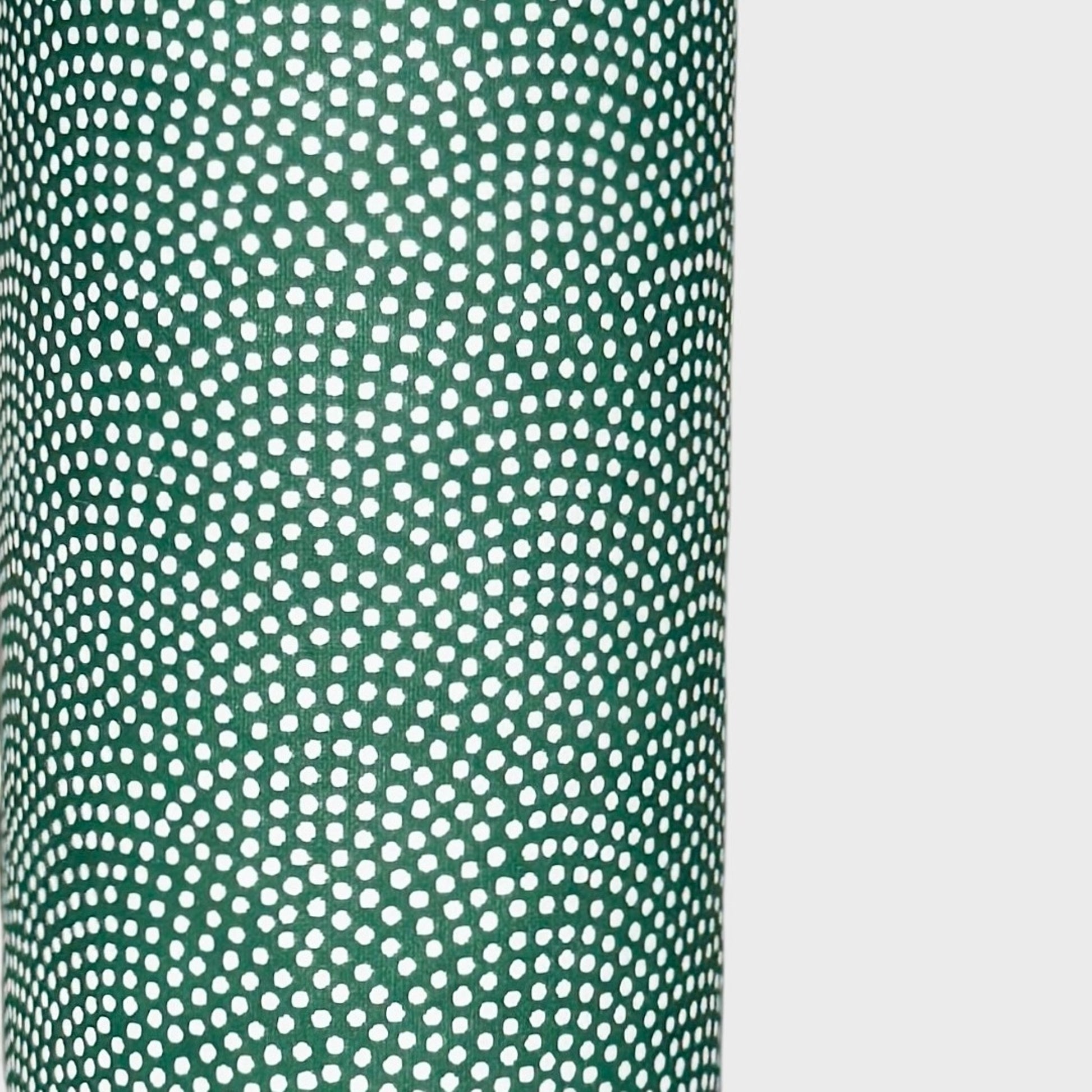 a sheet of Japanese chiyogami paper with a forest green background and a small repeat pattern of tiny white dots in an arch shape