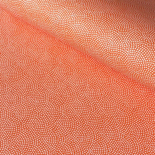 a sheet of chiyogami with a coral orange background and an small dotted arch pattern