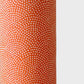 a sheet of chiyogami with a coral orange background and an small dotted arch pattern