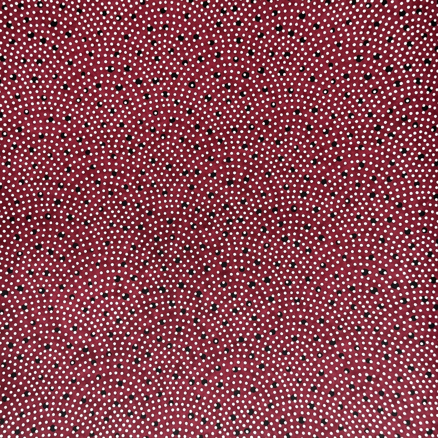 a sheet of Japanese chiyogami paper with an aubergine backdrop and a white dotted repeat arch pattern with black dots