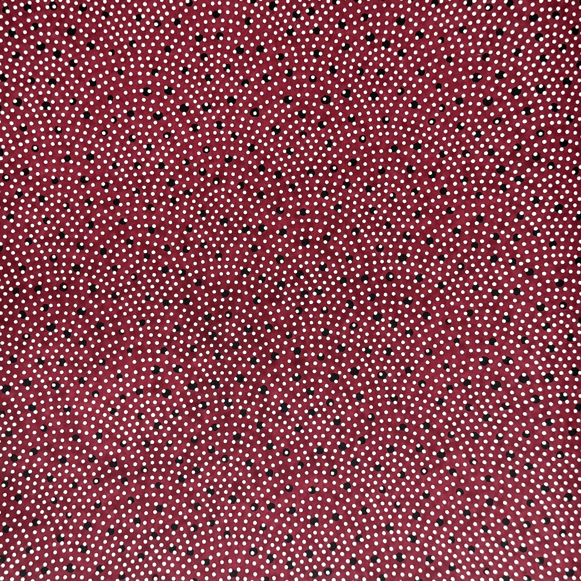 a sheet of Japanese chiyogami paper with an aubergine backdrop and a white dotted repeat arch pattern with black dots
