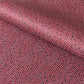 a sheet of Japanese chiyogami paper with an aubergine backdrop and a white dotted repeat arch pattern with black dots