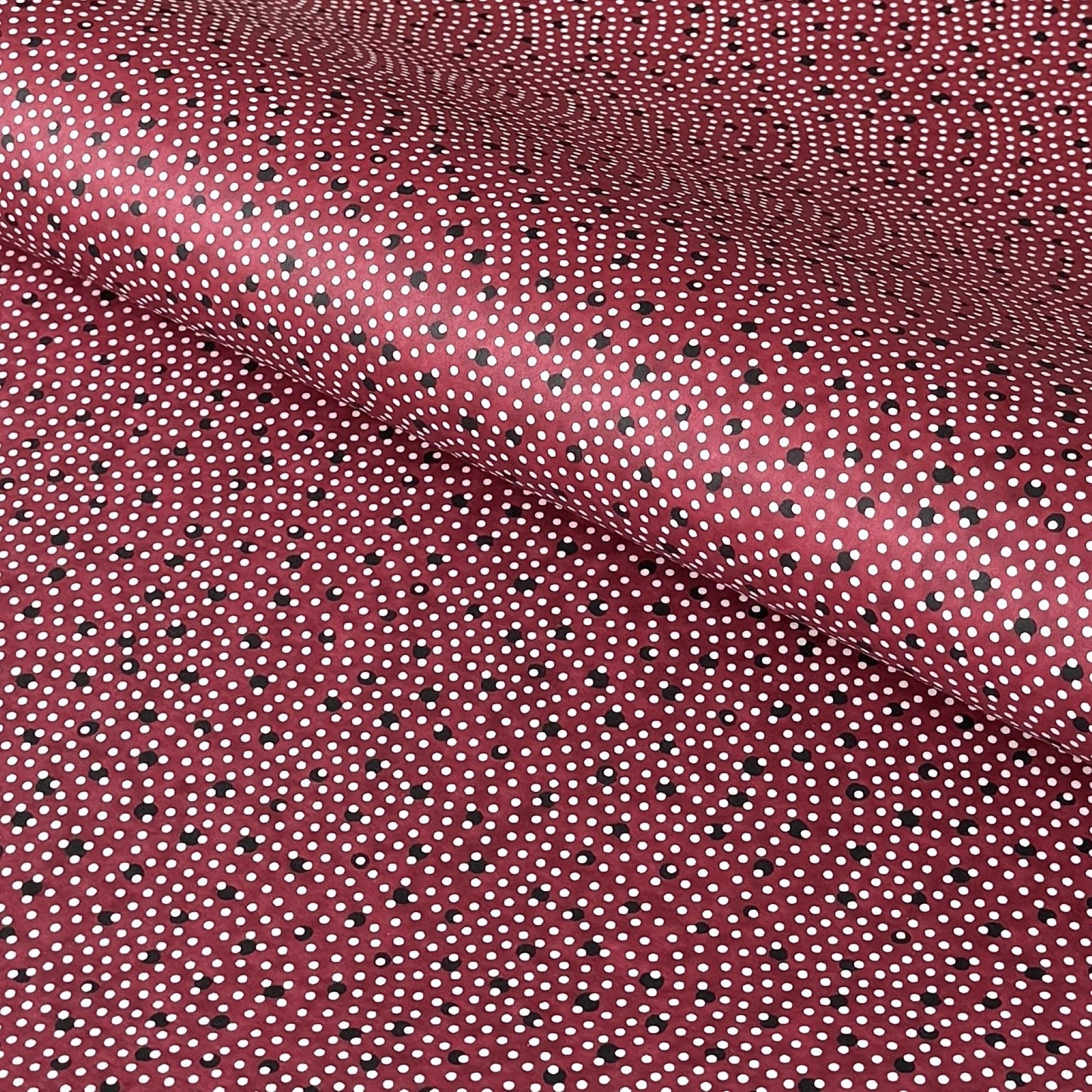 a sheet of Japanese chiyogami paper with an aubergine backdrop and a white dotted repeat arch pattern with black dots