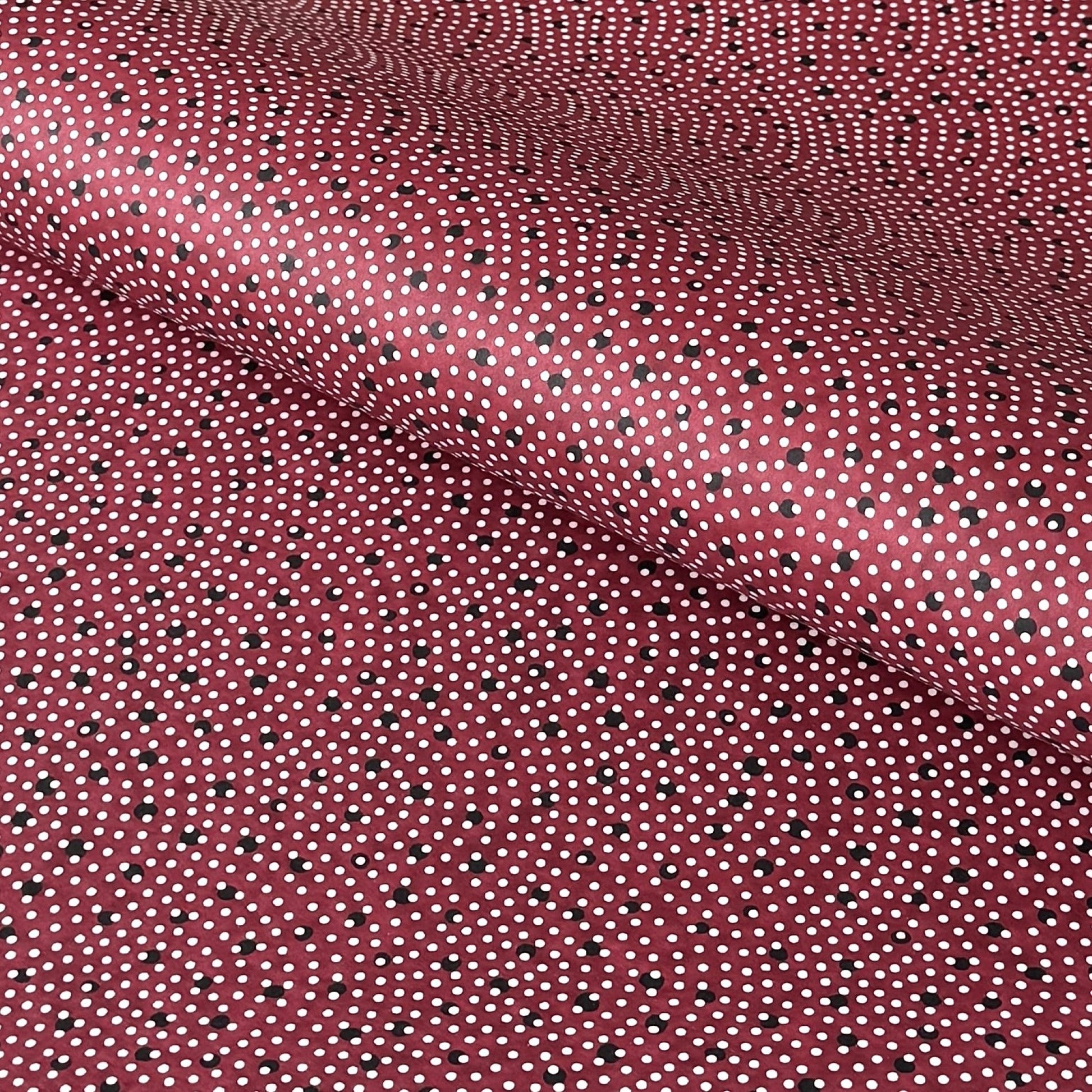 a sheet of Japanese chiyogami paper with an aubergine backdrop and a white dotted repeat arch pattern with black dots