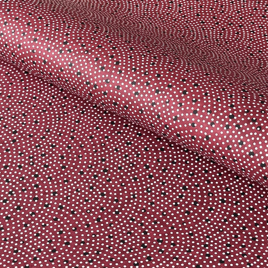 a sheet of Japanese chiyogami paper with an aubergine backdrop and a white dotted repeat arch pattern with black dots