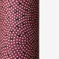 a sheet of Japanese chiyogami paper with an aubergine backdrop and a white dotted repeat arch pattern with black dots