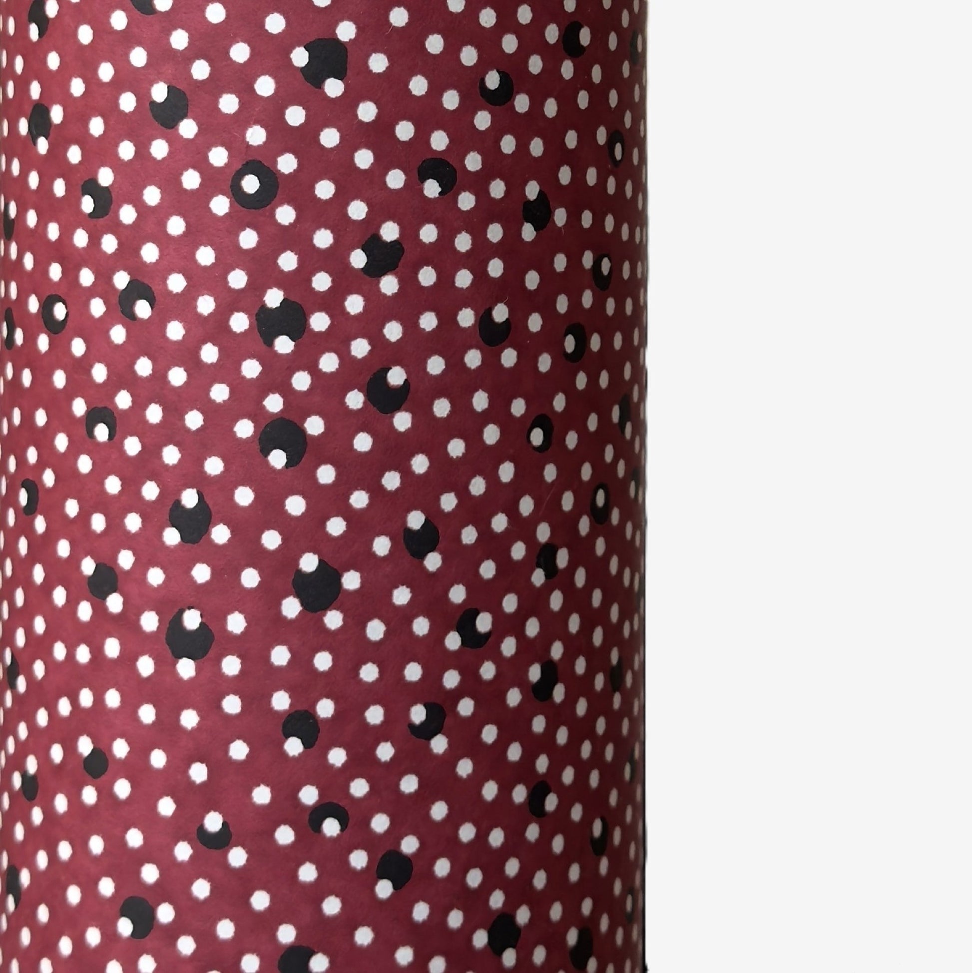 a sheet of Japanese chiyogami paper with an aubergine backdrop and a white dotted repeat arch pattern with black dots