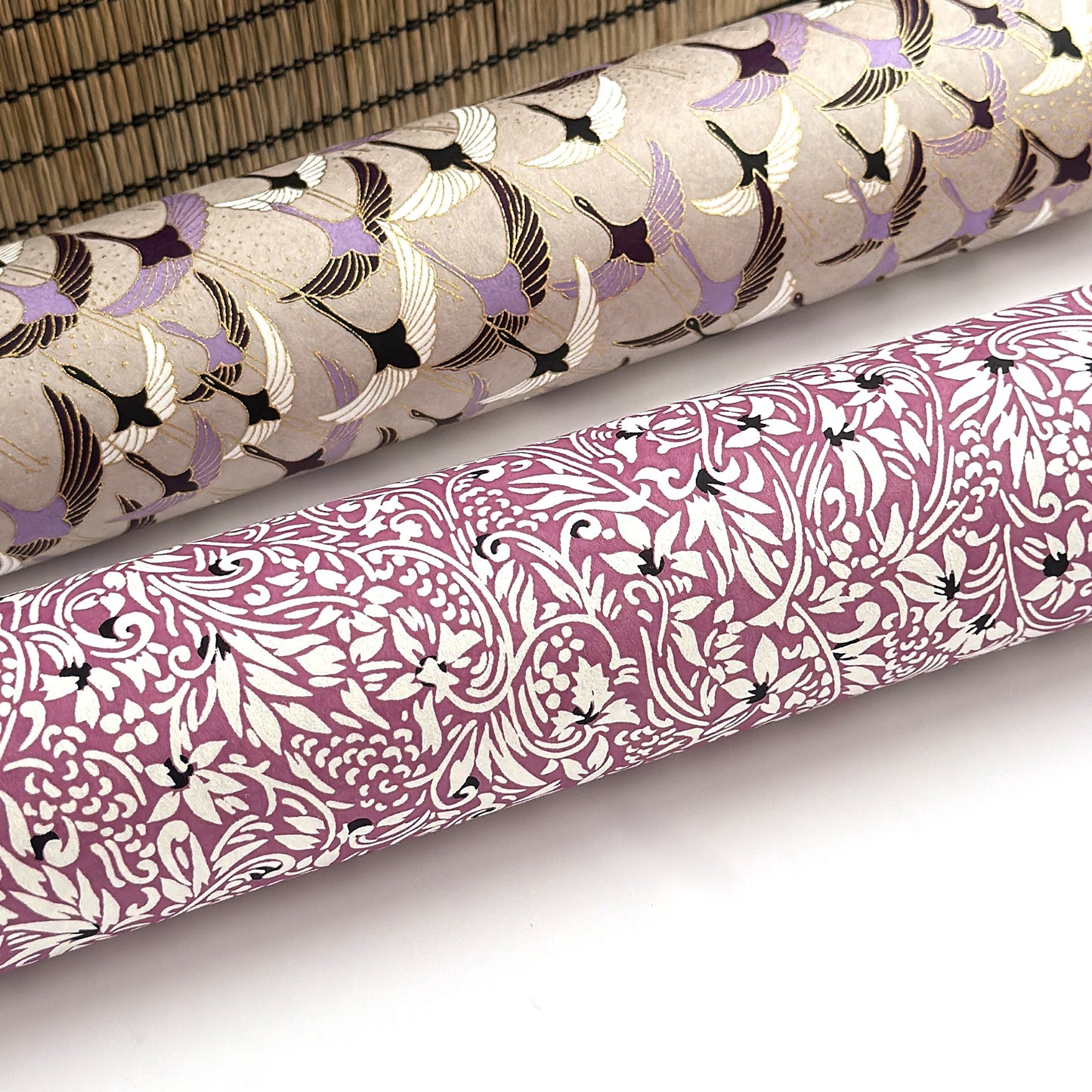 a sheet of Japanese silkscreen printed chiyogami yuzen paper with a micro floral pattern in aubergine, white and black. Rolled