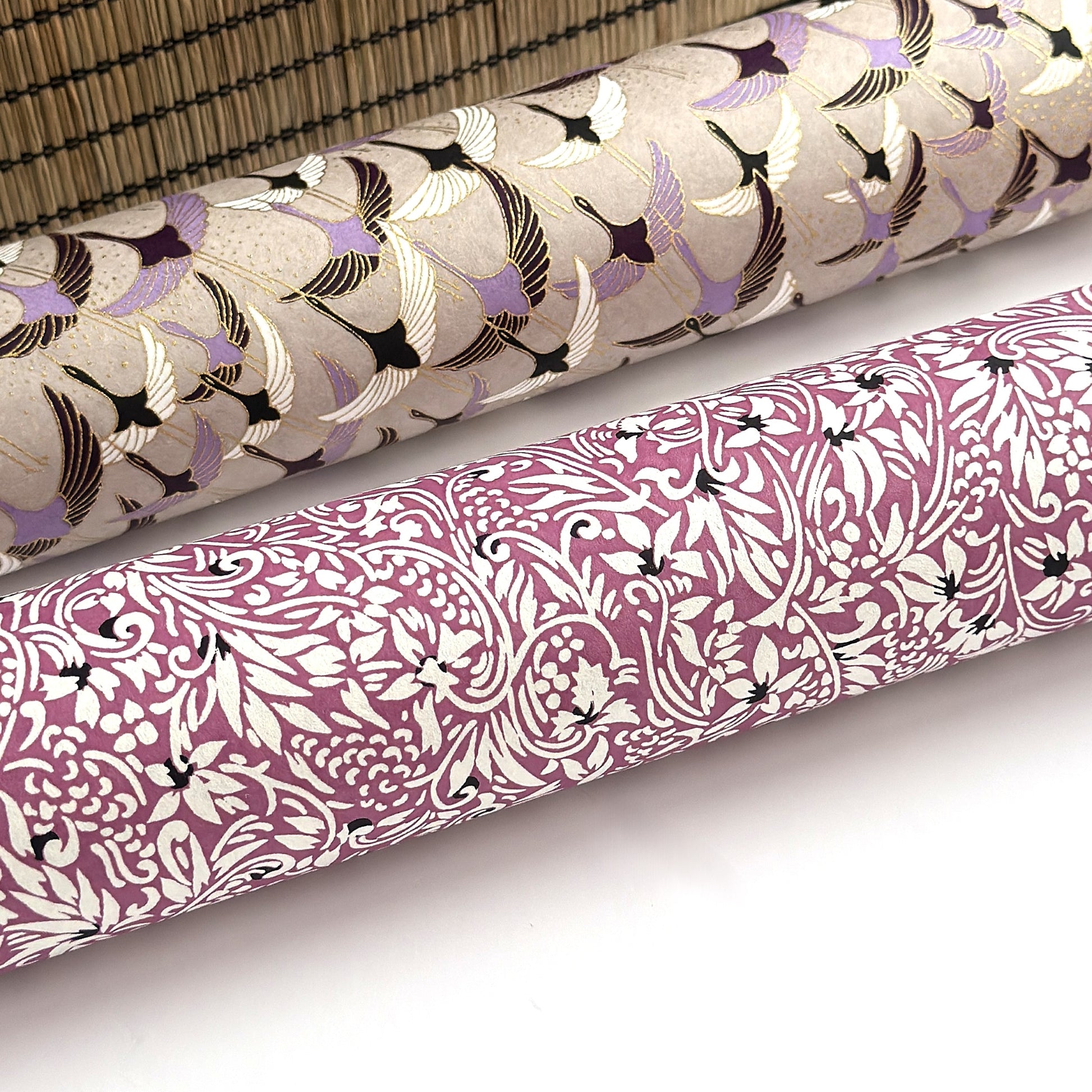 a sheet of Japanese silkscreen printed chiyogami yuzen paper with a micro floral pattern in aubergine, white and black. Rolled