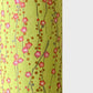 a sheet of chiyogami paper with a lime green background and vertical pattern of little plum flower trails in pink and gold