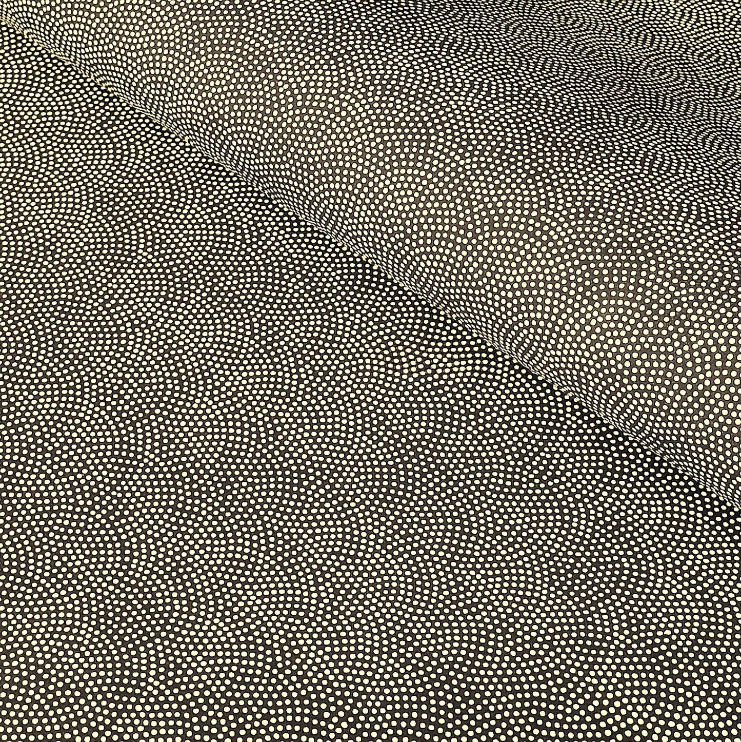 a sheet of Japanese chiyogami paper with a brown background and a small pattern of tiny cream dots in repeat arches