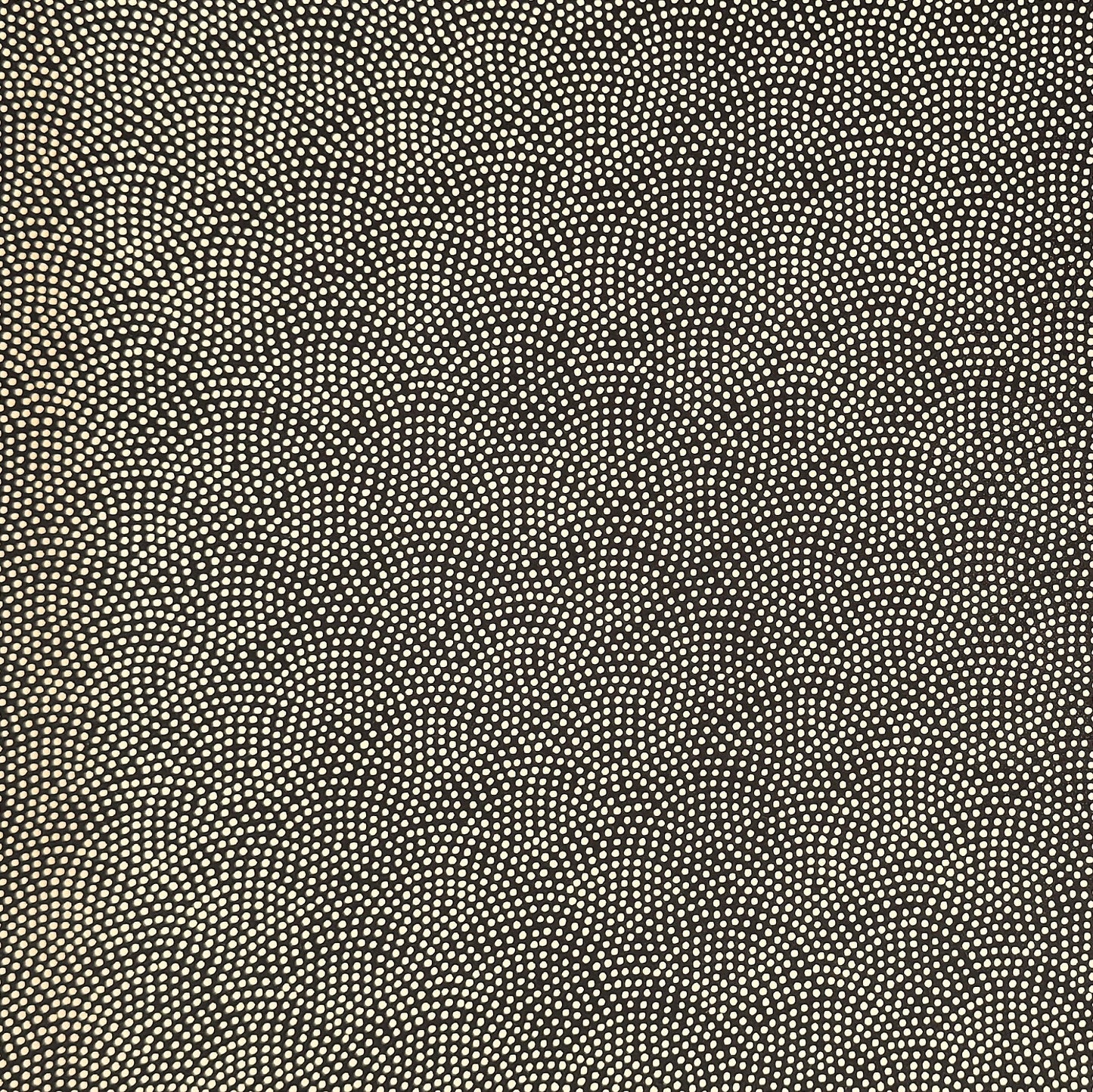 a sheet of Japanese chiyogami paper with a brown background and a small pattern of tiny cream dots in repeat arches