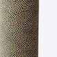 a sheet of Japanese chiyogami paper with a brown background and a small pattern of tiny cream dots in repeat arches