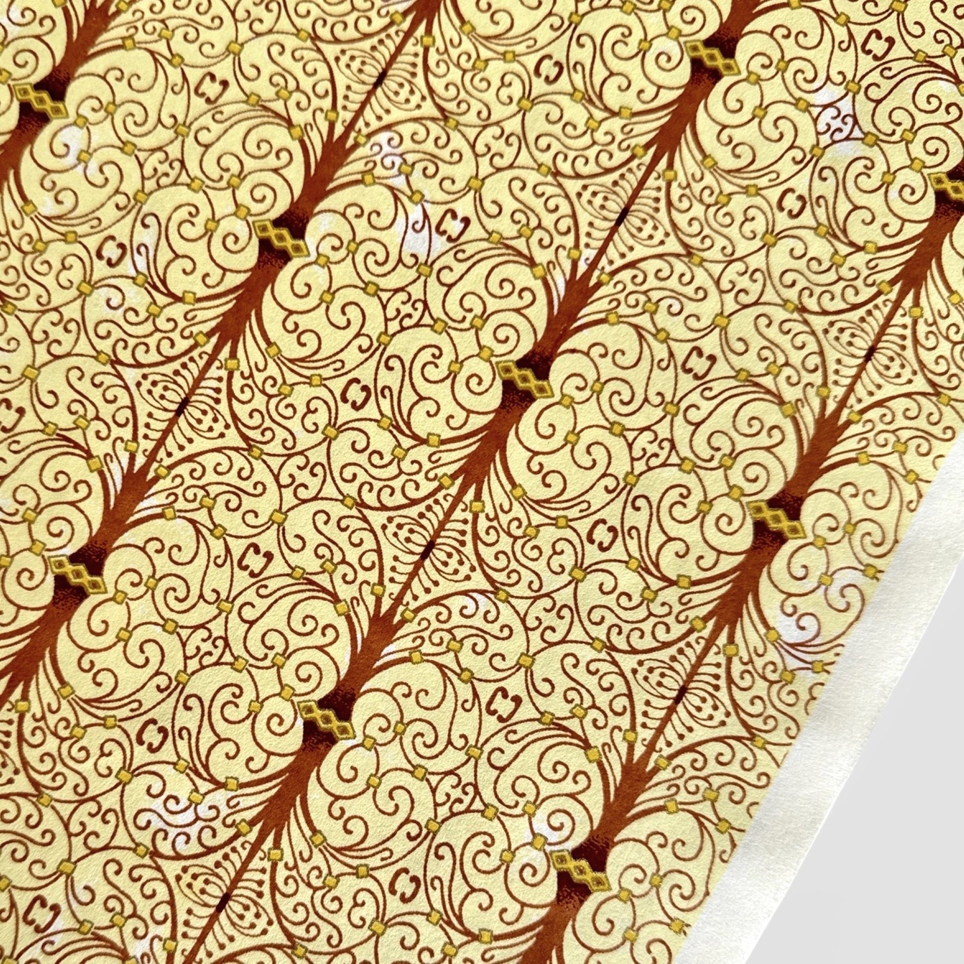 Japanese silkscreen chiyogami paper with a intricate filigree trellis design in brown with gold accent, close up