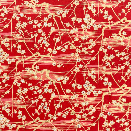 a sheet of Japanese silkscreen printed chiyogami paper with cream plum tree branches on red