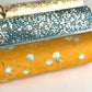 Pale blue plum (ume) blossom with a rich saffron backdrop.  Japanese chiyogami paper. Pictured rolled
