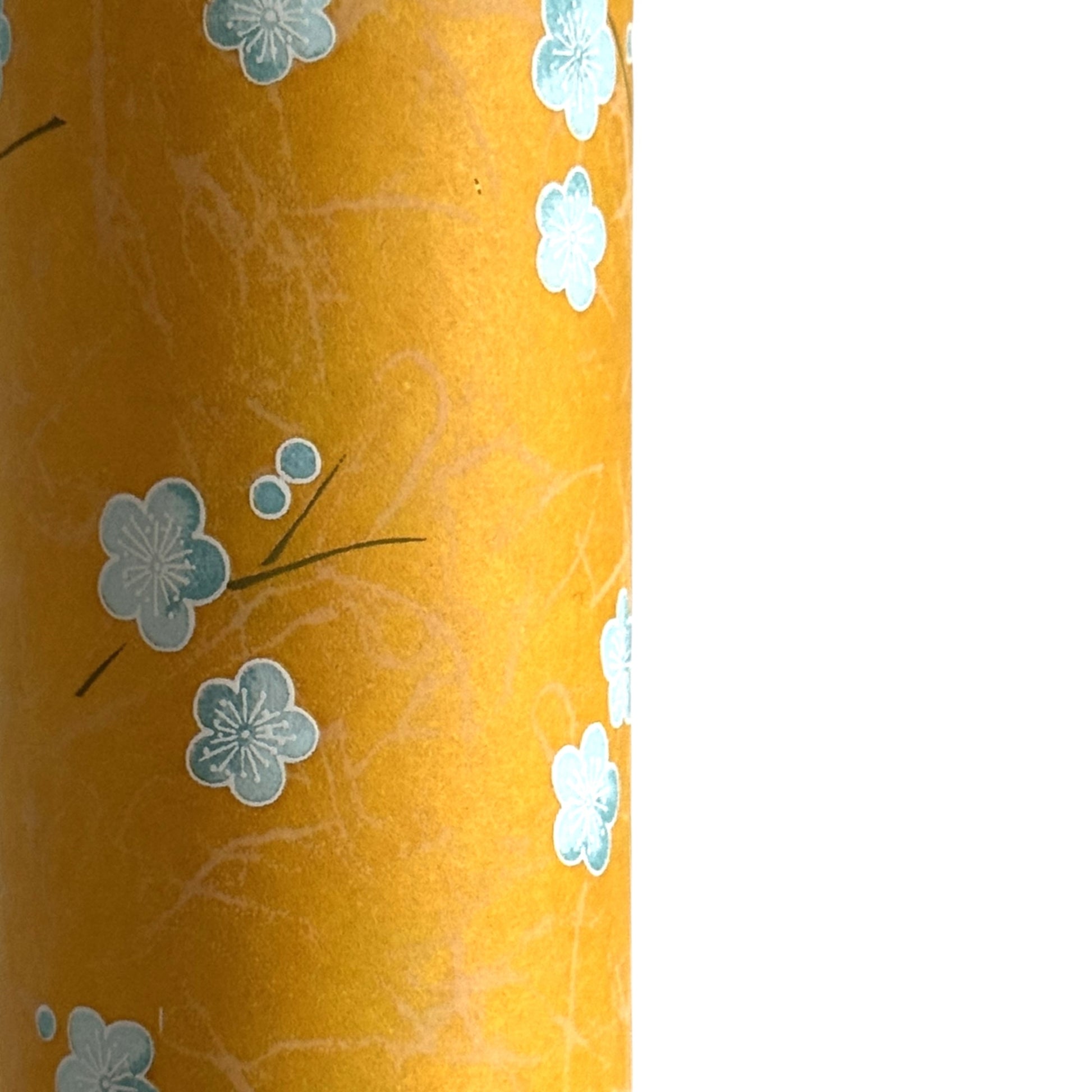 Pale blue plum (ume) blossom with a rich saffron backdrop.  Japanese chiyogami paper. Close up