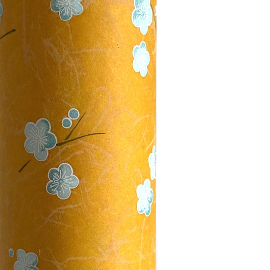Pale blue plum (ume) blossom with a rich saffron backdrop.  Japanese chiyogami paper. Close up
