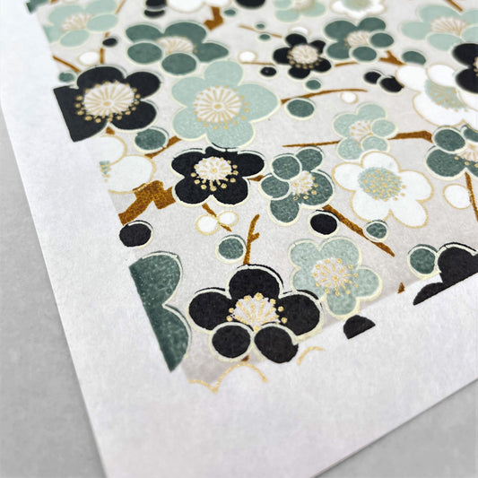 japanese silk-screen handmade paper showing soft green plum flower repeat pattern with gold highlights