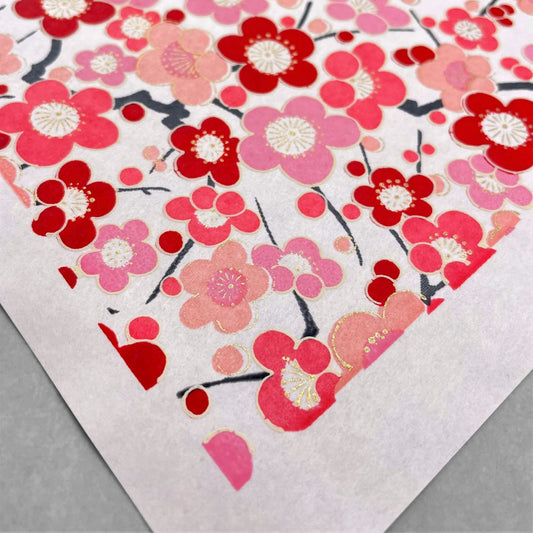 japanese silk-screen handmade paper showing pink and red plum flower repeat pattern with gold highlights
