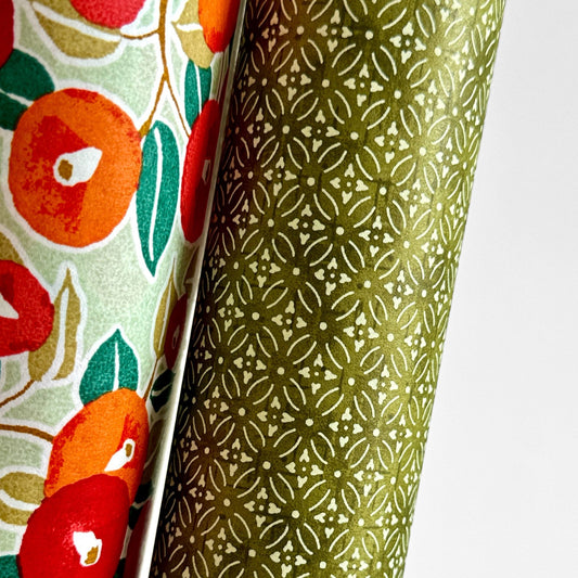 Japanese silkscreen chiyogami paper with a two-tone rich green geometric pattern on creamy white. Close-up