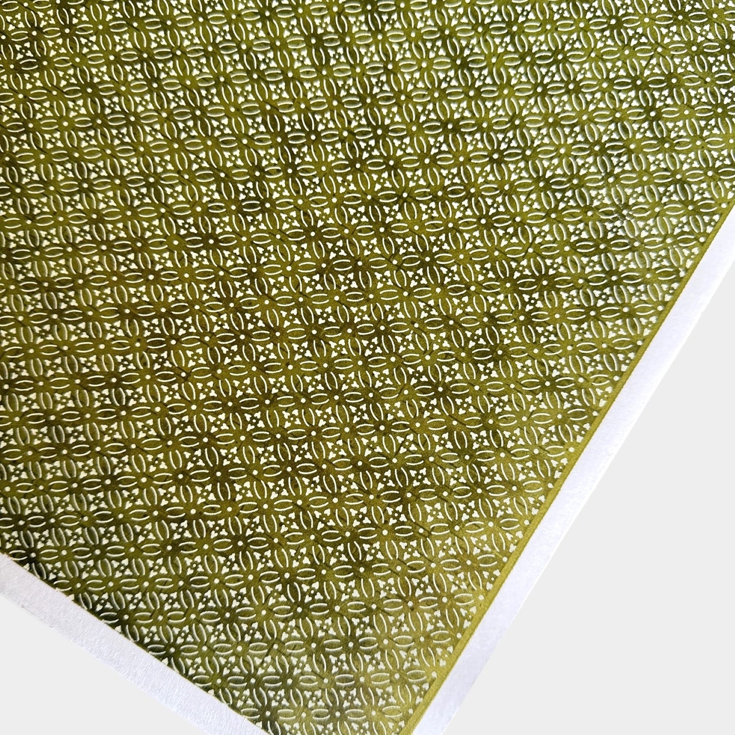 Japanese silkscreen chiyogami paper with a two-tone rich green geometric pattern on creamy white