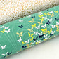 Japanese silkscreen chiyogami paper with a delicate butterfly pattern on a teal backdrop. Close up