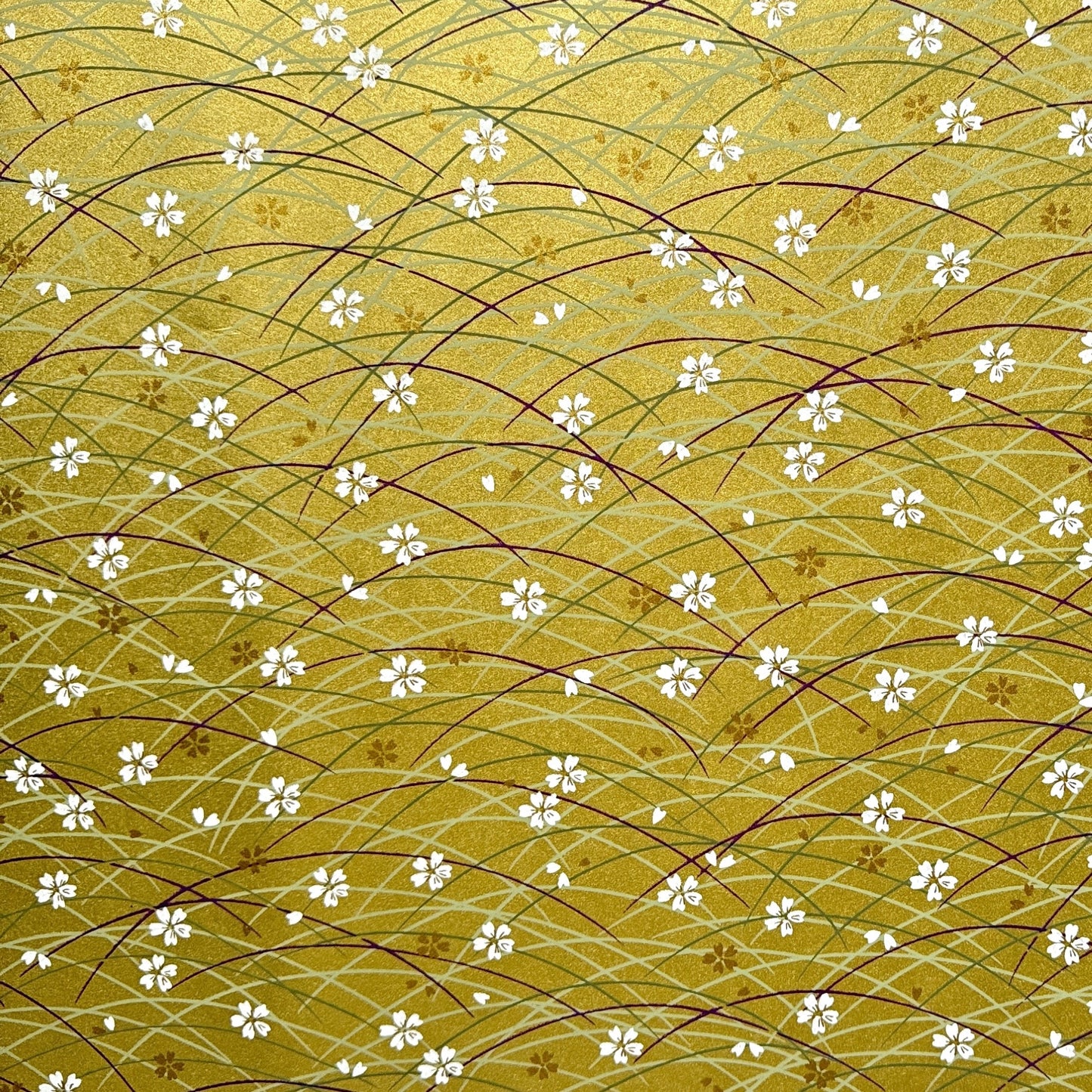 Japanese silkscreen chiyogami paper with a pattern of purple arches and white cherry blossom on antique gold backdrop