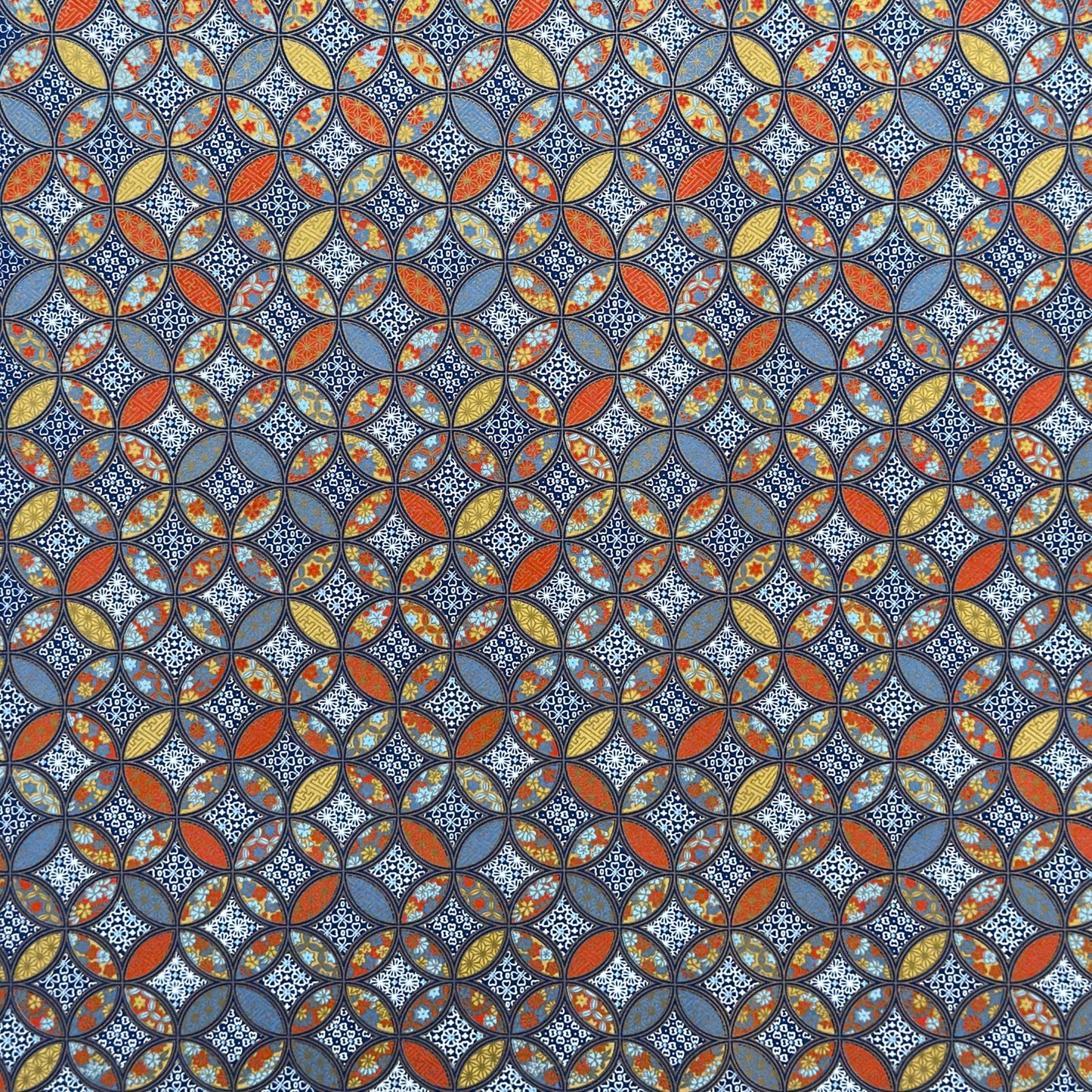 a sheet of Japanese silkscreen printed chiyogami yuzen paper with a design of overlapping circles in blue, red, yellow and white