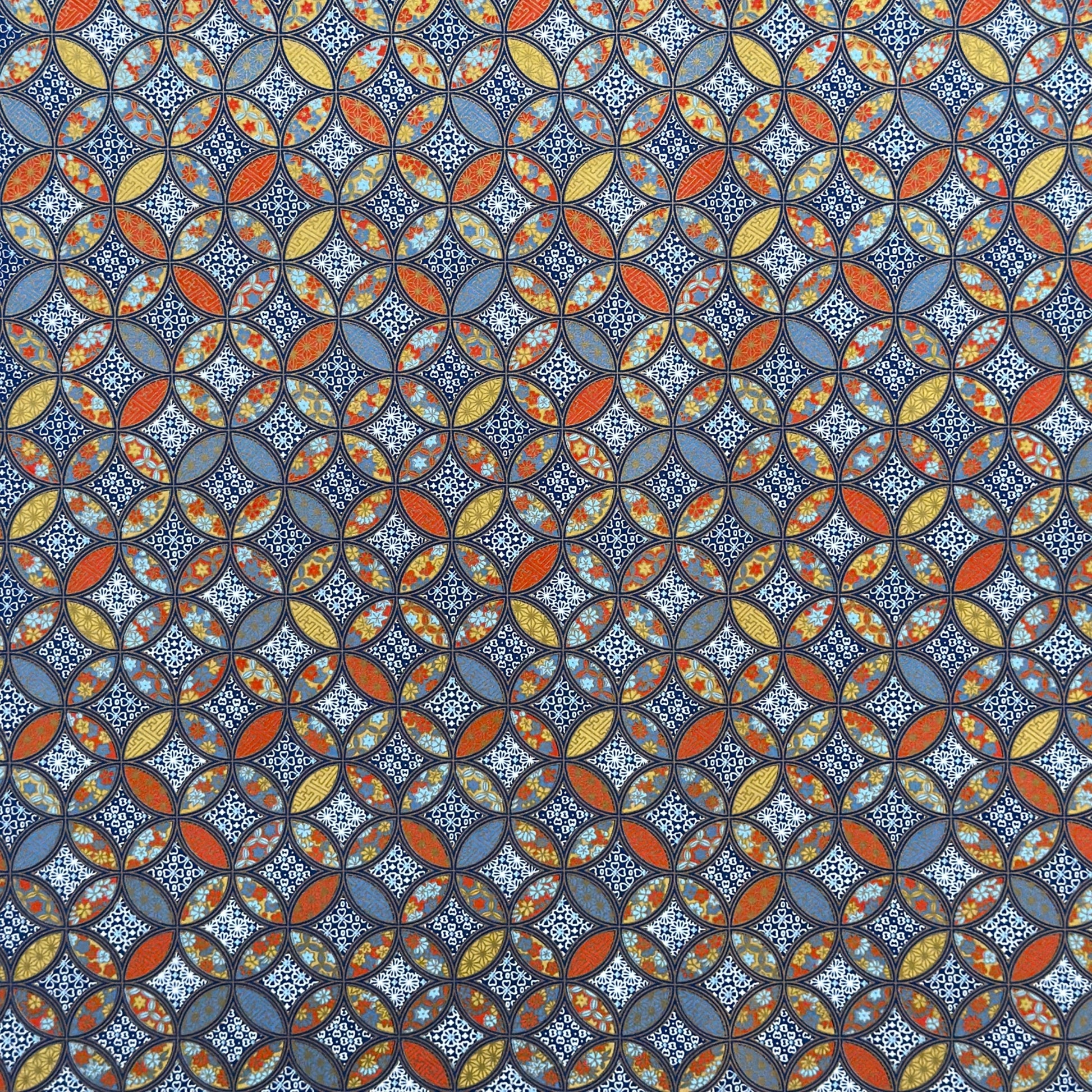 a sheet of Japanese silkscreen printed chiyogami yuzen paper with a design of overlapping circles in blue, red, yellow and white