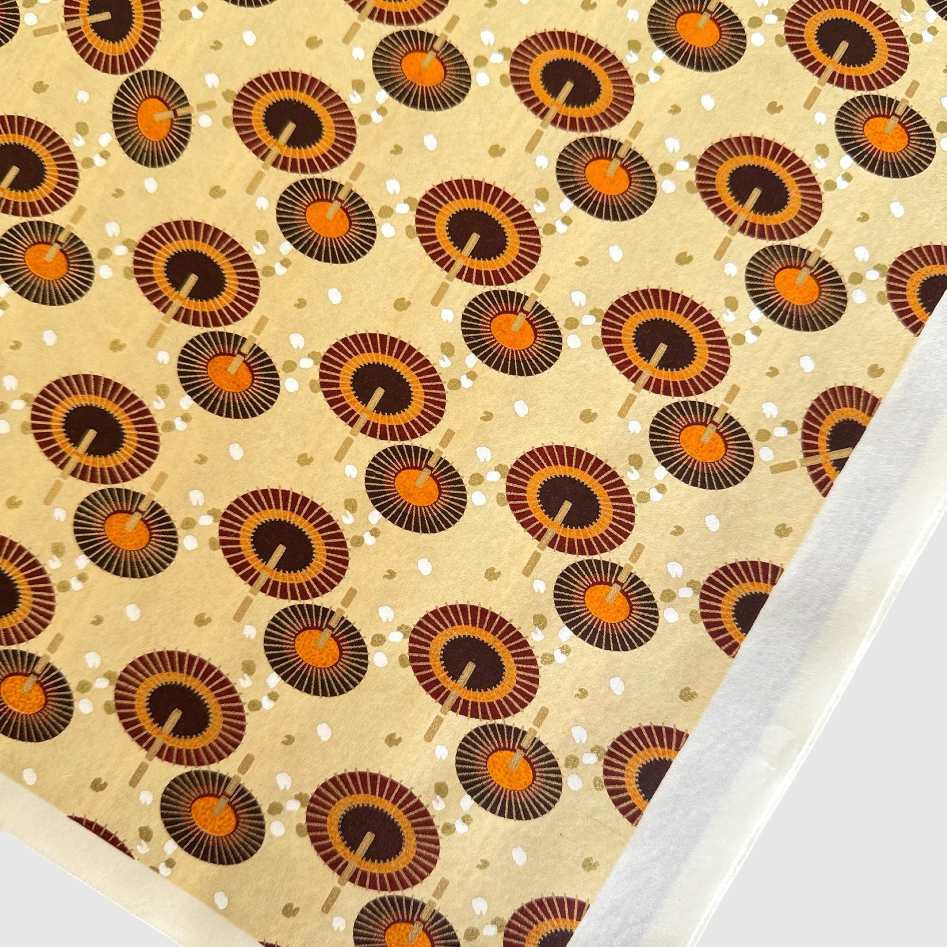 Japanese silkscreen chiyogami paper with a brown and orange umbrella pattern on a buttermilk backdrop