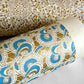 Japanese silkscreen chiyogami paper with a repeat floral pattern in gold an cerulean blue, close up