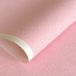 a sheet of chiyogami paper with a pink background and little irregular white dots with a gold center