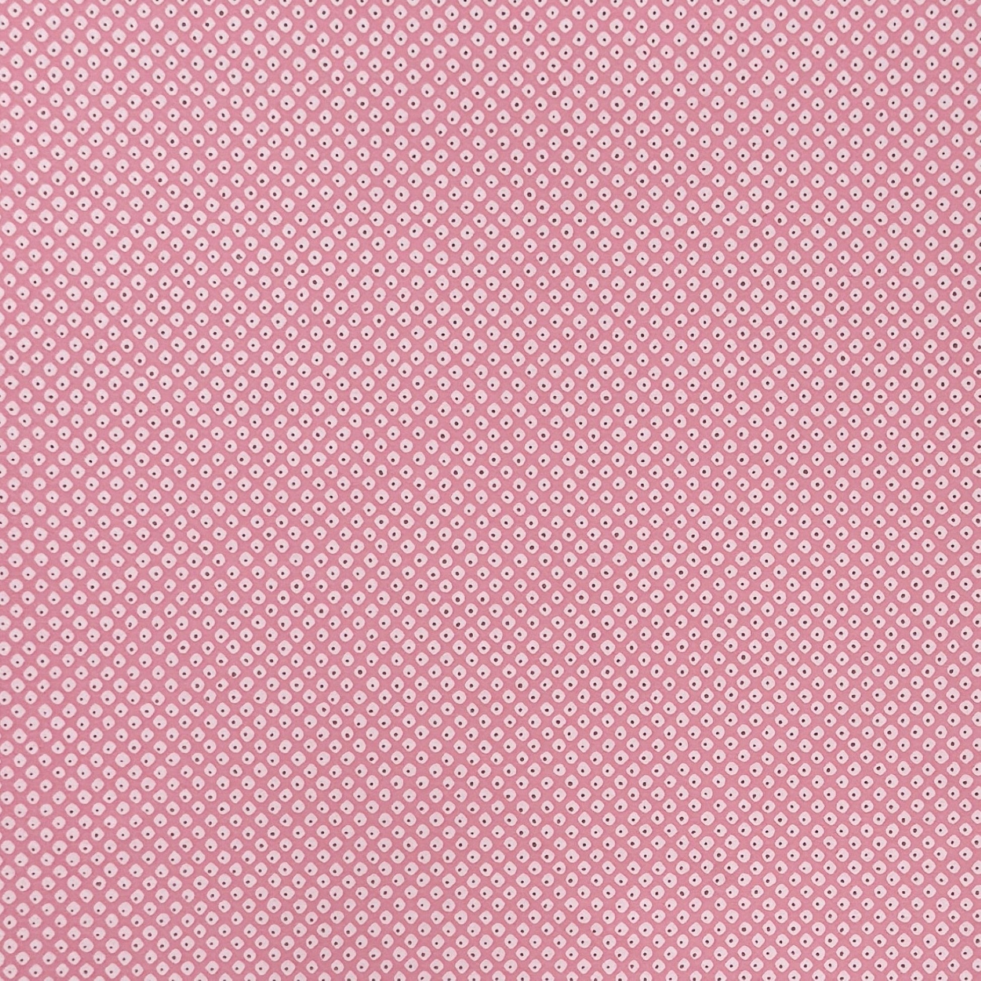 a sheet of chiyogami paper with a pink background and little irregular white dots with a gold center