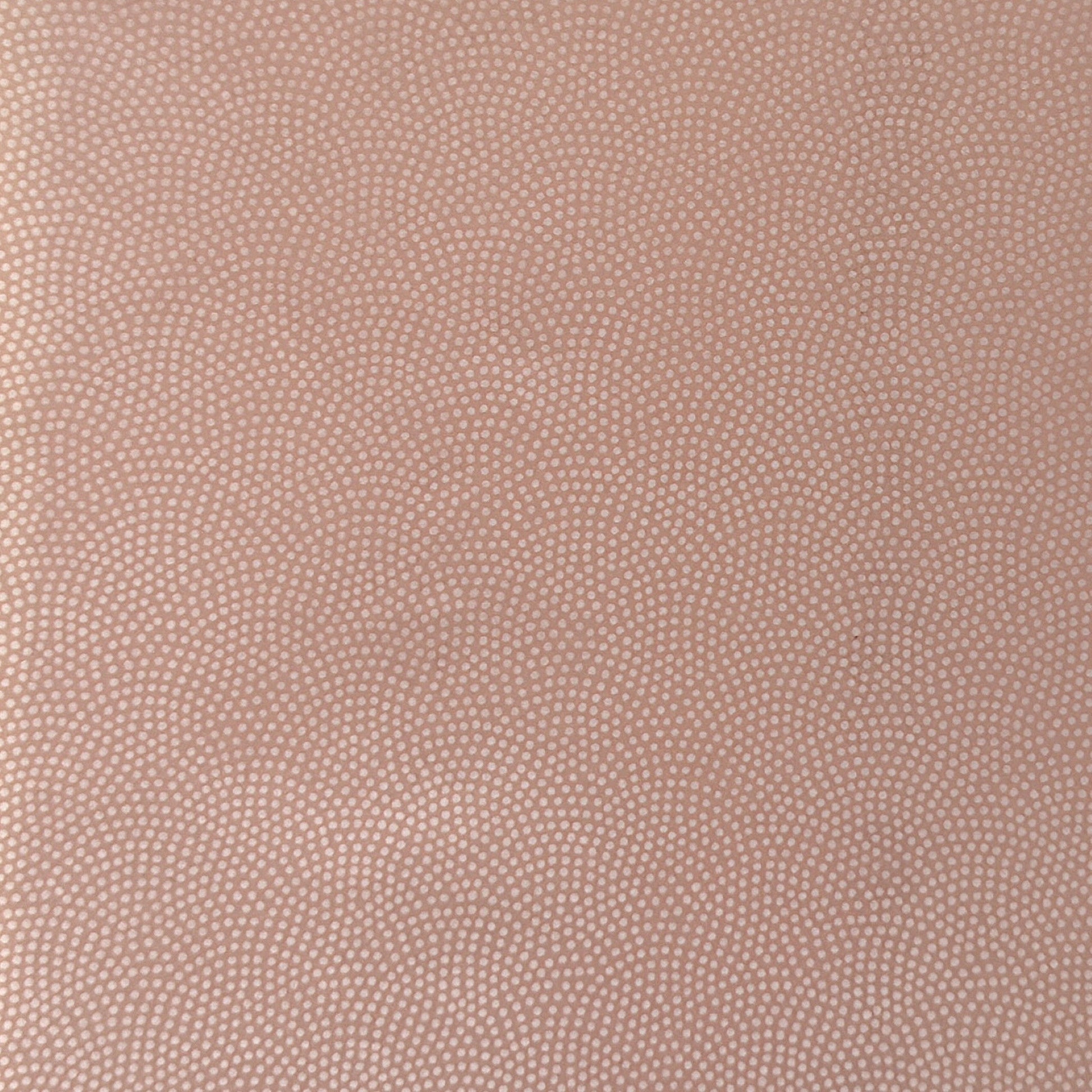 a sheet of Japanese chiyogami paper with a blush pink background and a small pattern of white dots in repeating arch shape