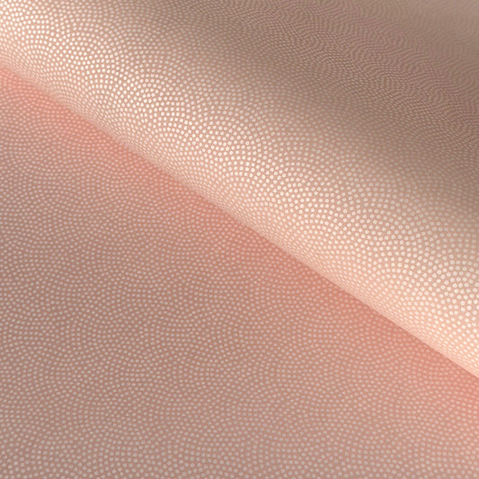 a sheet of Japanese chiyogami paper with a blush pink background and a small pattern of white dots in repeating arch shape