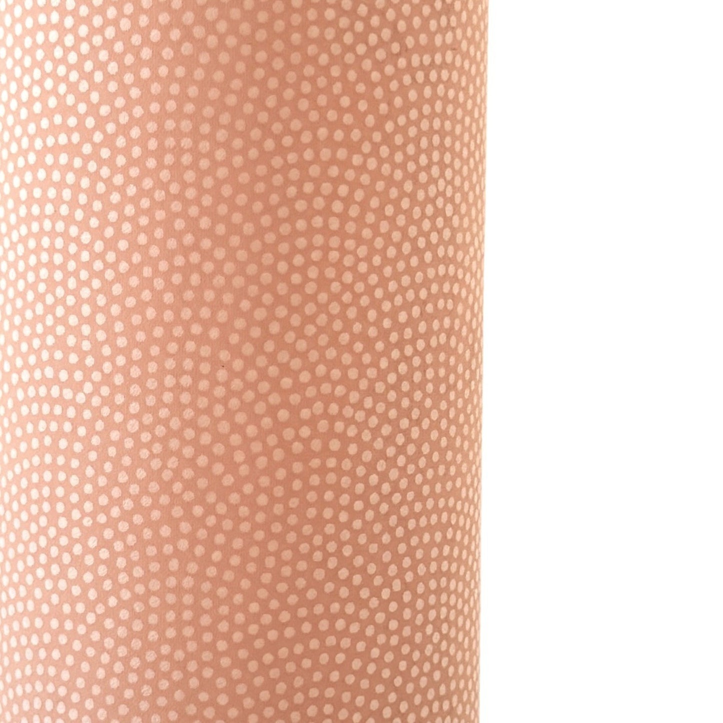 a sheet of Japanese chiyogami paper with a blush pink background and a small pattern of white dots in repeating arch shape