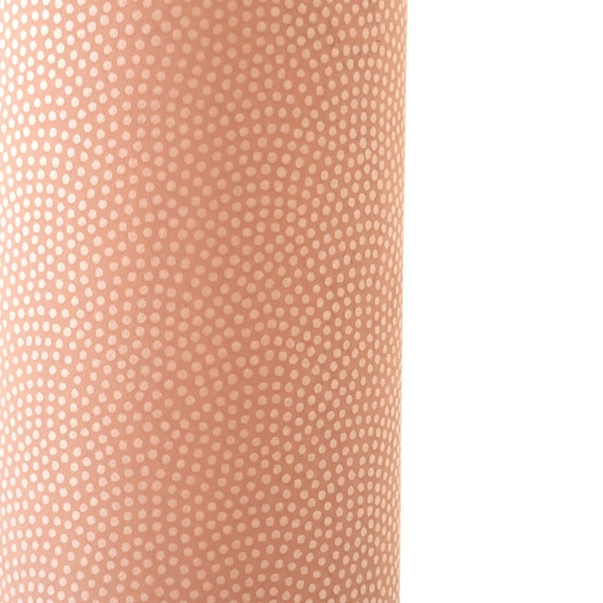 a sheet of Japanese chiyogami paper with a blush pink background and a small pattern of white dots in repeating arch shape