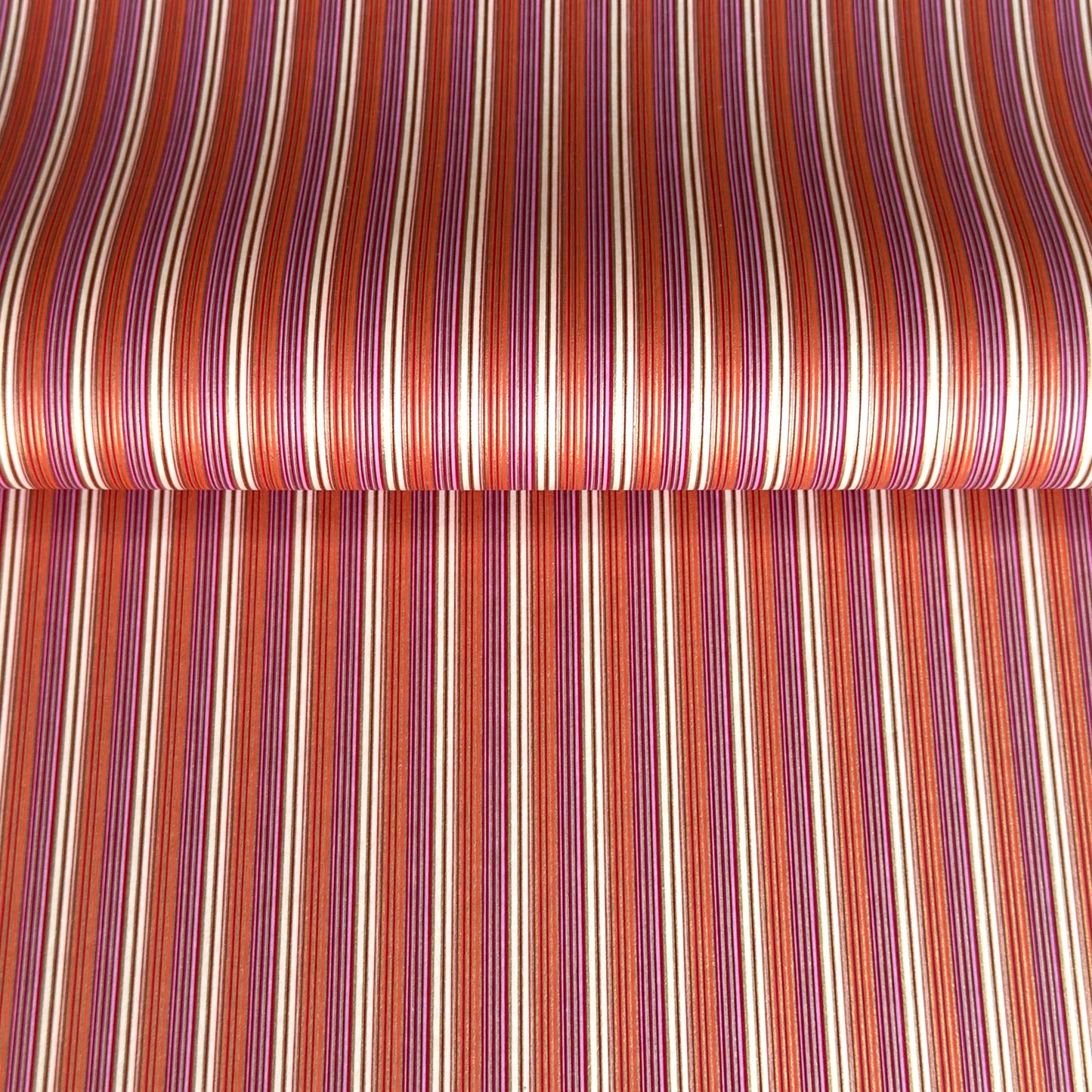 Japanese silkscreen chiyogami paper with a classic narrow stripe pattern in berry tones of red, pink, purple and gold.