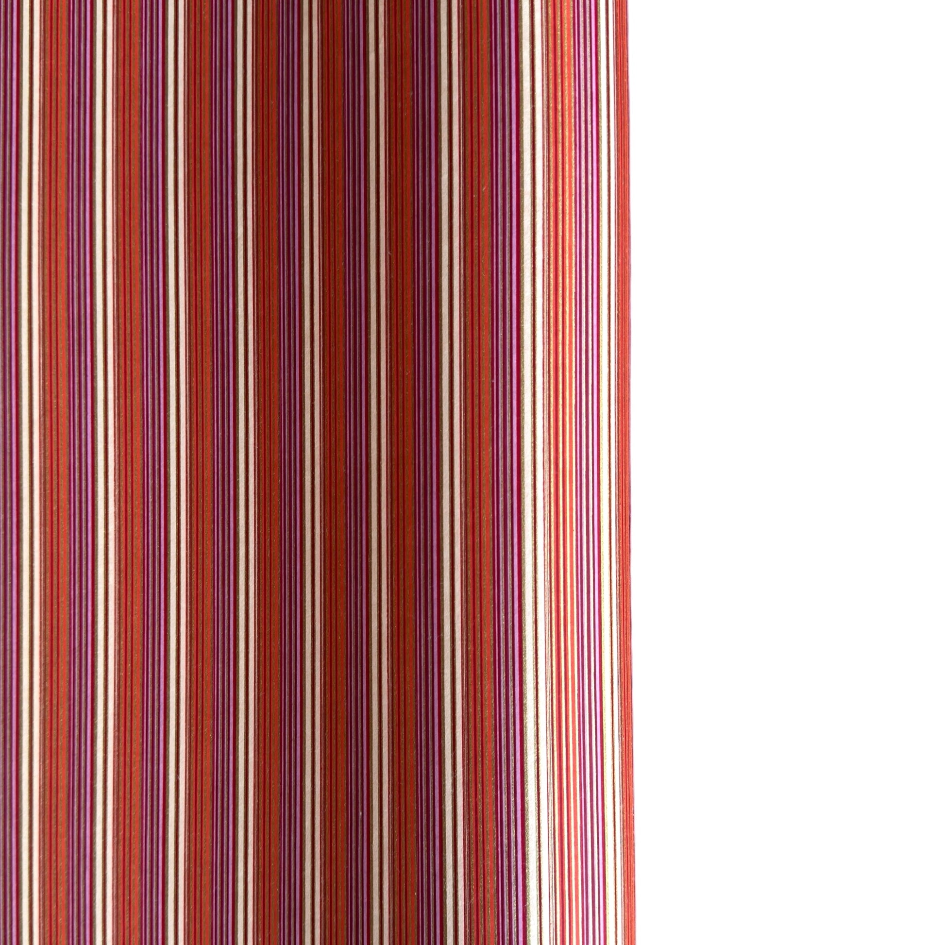 Japanese silkscreen chiyogami paper with a classic narrow stripe pattern in berry tones of red, pink, purple and gold.