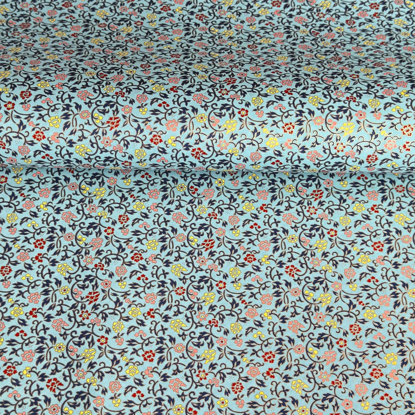Japanese silkscreen chiyogami paper with a dainty floral pattern in navy, yellow and coral on a teal backdrop. Finished with gold metallic ink.