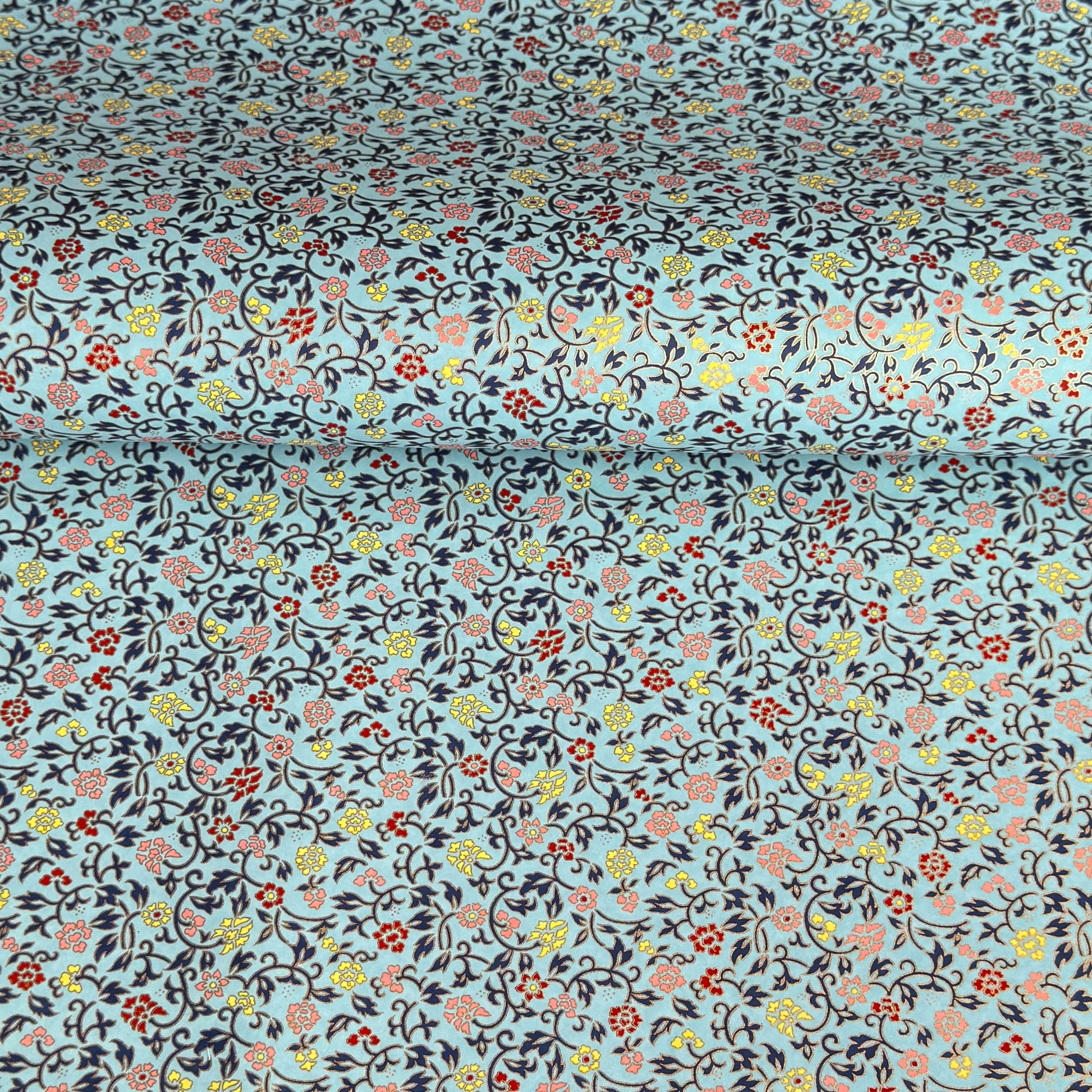 Japanese silkscreen chiyogami paper with a dainty floral pattern in navy, yellow and coral on a teal backdrop. Finished with gold metallic ink.