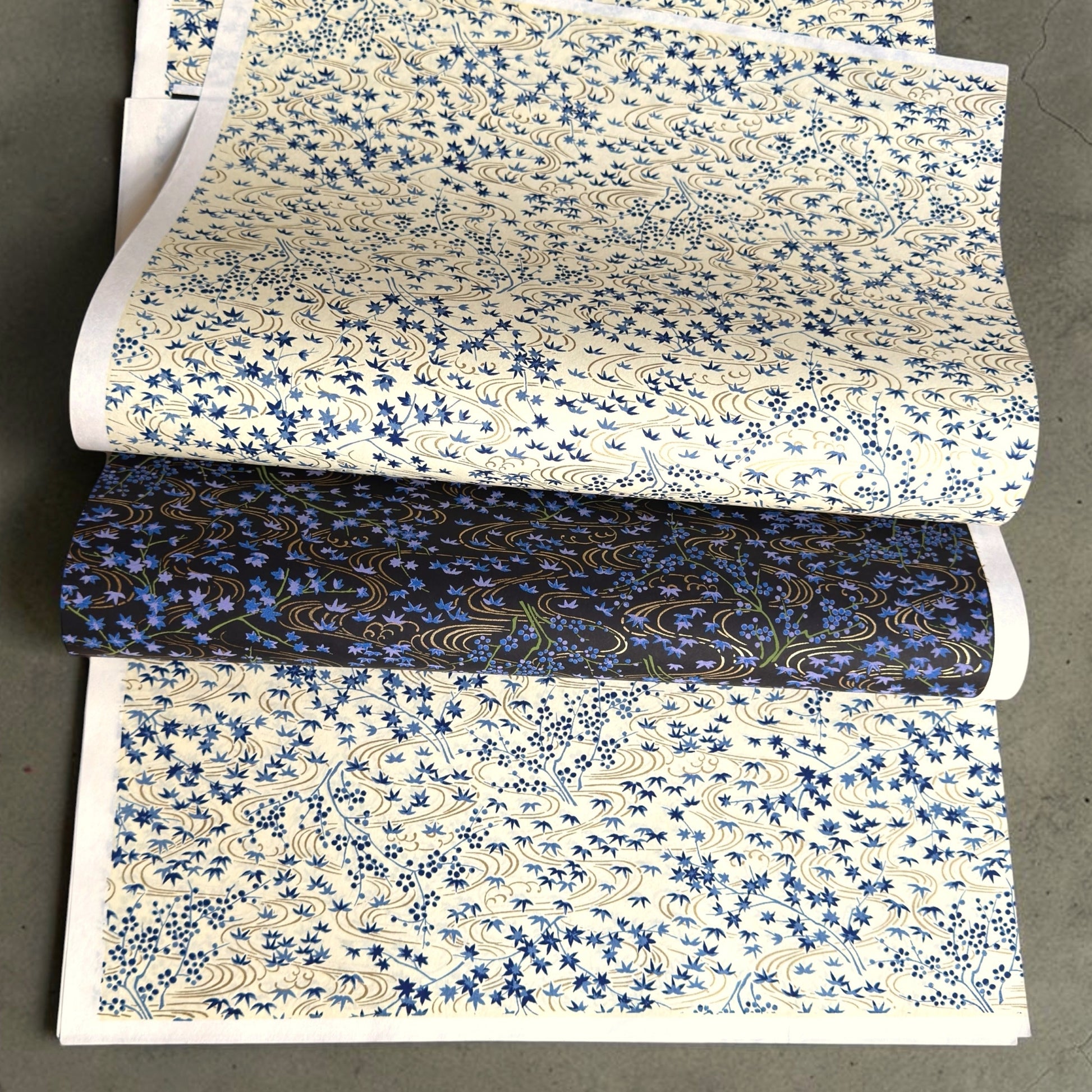 japanese silk-screen handmade paper showing gold rivers and blue falling leaves and foliage