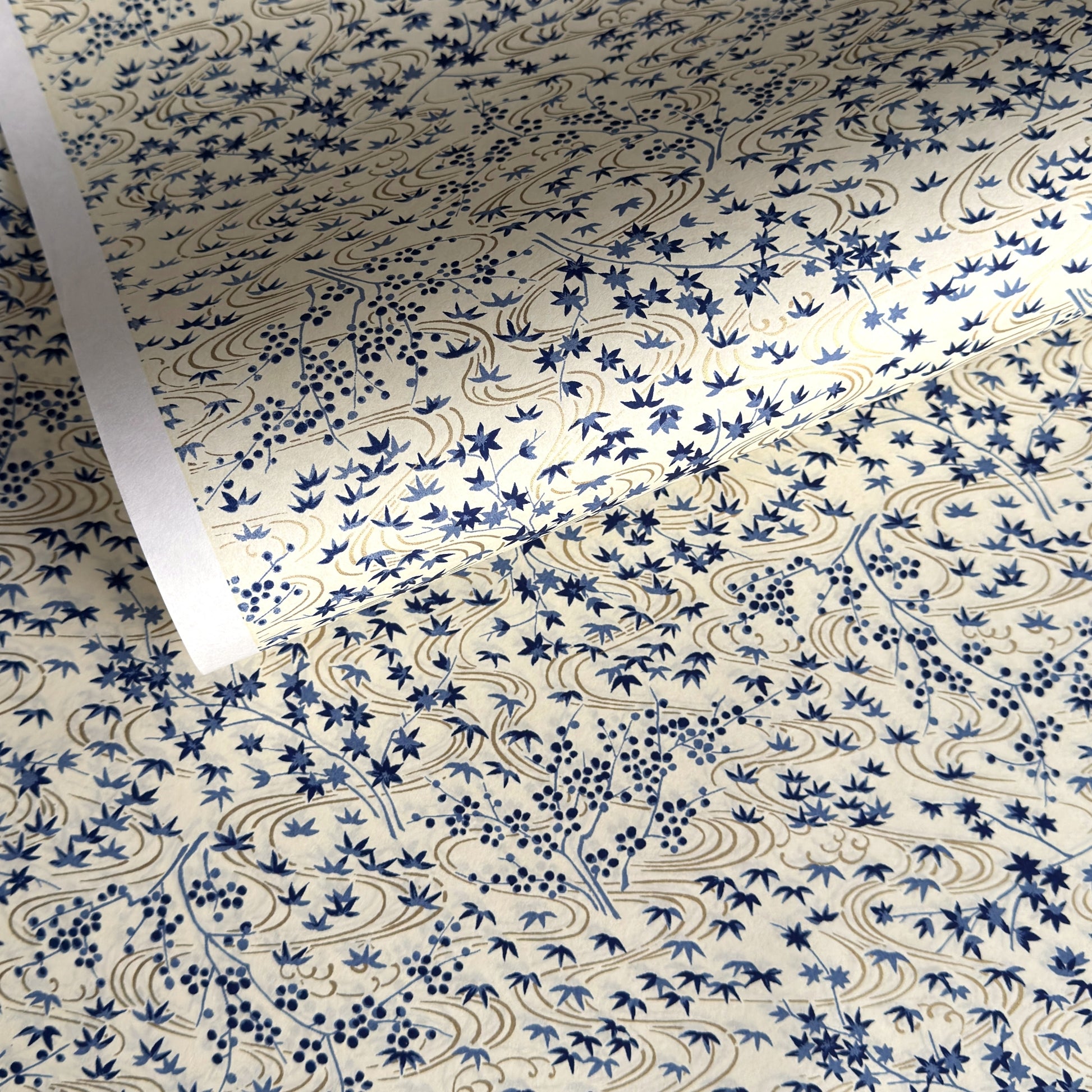 japanese silk-screen handmade paper showing gold rivers and blue falling leaves and foliage