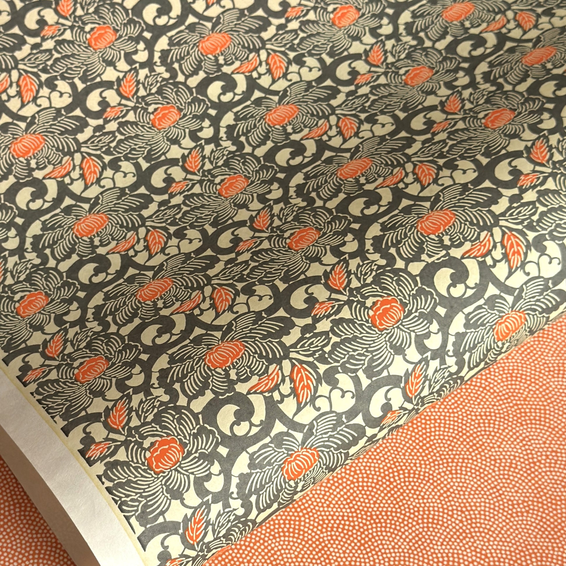 japanese silk-screen handmade paper showing grey and orange peony flower repeat pattern