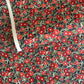 japanese silk-screen handmade paper, chiyogami, with a design showing red and pink camellia flowers and green leaves on black background