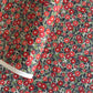 japanese silk-screen handmade paper, chiyogami, with a design showing red and pink camellia flowers and green leaves on black background