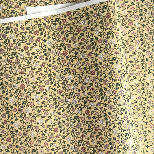 Japanese chiyogami silkscreen paper with a dainty floral pattern on a creamy backdrop and finished with gold metallic ink. 